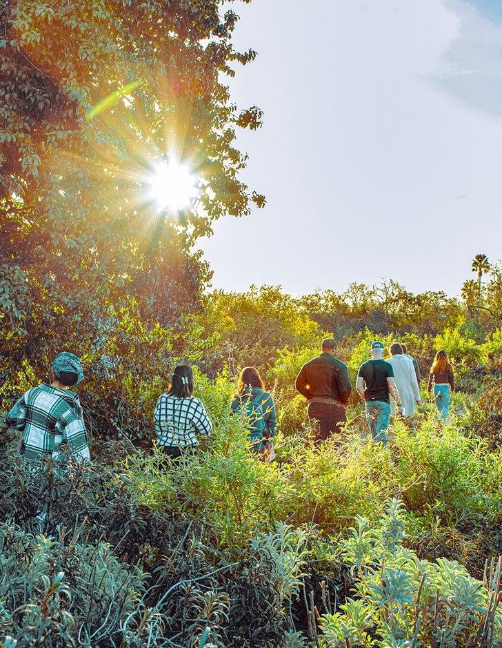 a group of students walks in the brush of Pitzer's outback